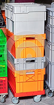 Plastic colored containers on top of each other on a mobile wheeled trolley