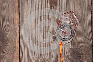Plastic compass over a wooden background