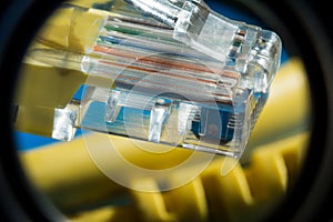 Plastic connector and yellow cable type twisted pair for connection to a computer network, macro abstract background