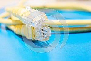 Plastic connector and yellow cable type twisted pair for connection to a computer network, macro abstract background