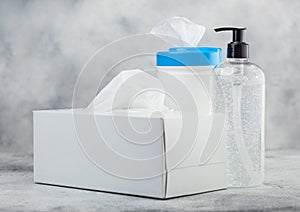 Plastic container with alcohol wipes with hand sanitizer plastic container and box of tissues on light background. Best protection