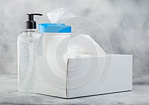 Plastic container with alcohol wipes with hand sanitizer plastic container and box of tissues on light background. Best protection