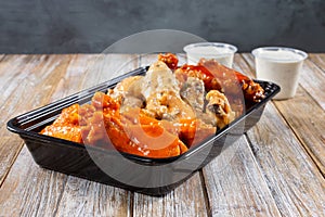 plastic container of assorted chicken wings, wing sampler