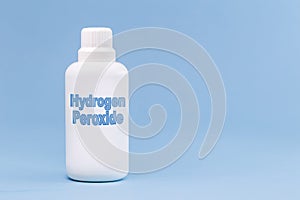 Plastic container, medicine bottle, written in english: hydrogen peroxide, isolated blue background, concept of first care photo