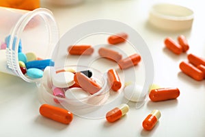 Plastic container with pills on table