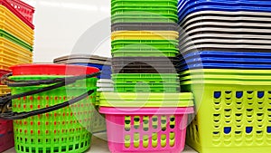 Plastic containers of different colors and prices are placed in a warehouse or store on display racks. Recycled plastic for sale,