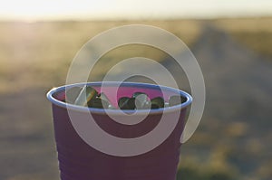 A plastic cup full of empty shells