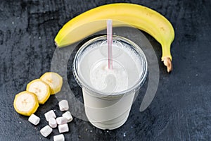 Plastic cup of milkshake with banana