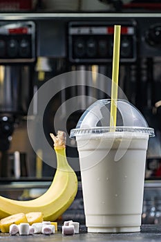 Plastic cup of milkshake with banana