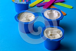 Plastic cup with tasty yogurt on blue table