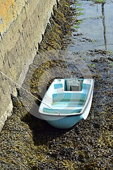 Plastic dinghy at stone pier