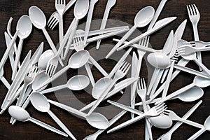 Plastic disposable tableware scattered on wooden table
