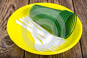 Plastic disposable tableware on wooden table