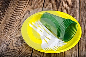 Plastic disposable tableware on wooden table