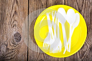 Plastic disposable tableware on wooden table