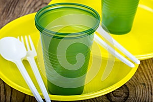 Plastic disposable tableware on wooden table