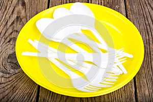 Plastic disposable tableware on wooden table