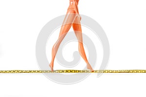 A plastic doll walking on a measuring tape