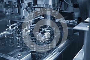 The plastic drinking bottles in the  blowing mold machine.