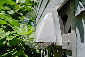Plastic dryer exhaust vent hood on side of house