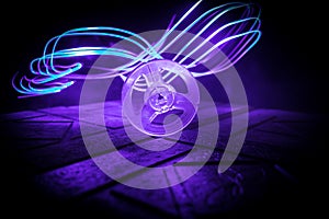 Plastic empty bobbin on dark toned background with light. Music concept