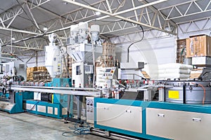 Plastic extrusion manufacturing machine in modern industrial factory, automated polymer processing line for plastic