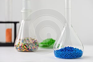 Plastic factory laboratory. Glass flasks with colored dye in granules for plastics. polymer industry