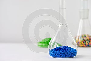 Plastic factory laboratory. Glass flasks with colored dye in granules for plastics. polymer industry