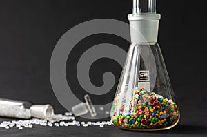 Plastic factory laboratory. Glass flasks with colored dye in granules for plastics. polymer industry