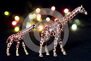 Plastic figurines of giraffes in a savannah-like environment at night