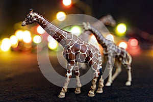 Plastic figurines of giraffes in a savannah-like environment at night