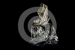 Plastic foil from a disposable bag shown like an art sculpture against a black background, packaging waste of abundance and