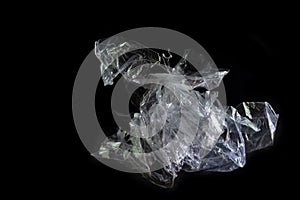 Plastic foil from a disposable bag shown like a horse sculpture against a black background, packaging waste of abundance and