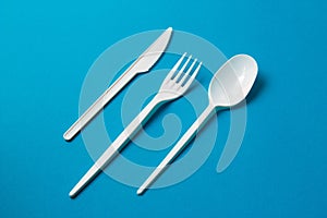 Plastic Fork, Spoon and Knive on Blue Background photo