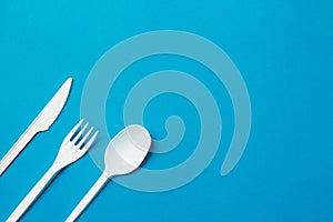 Plastic Fork, Spoon and Knive on Blue Background photo