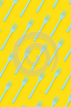 Plastic forks flat lay on yellow background