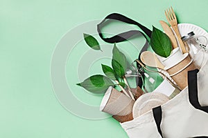 Plastic free set with cotton bag, glass jar, green leaves and recycled tableware top view. Zero waste, eco friendly concept. photo