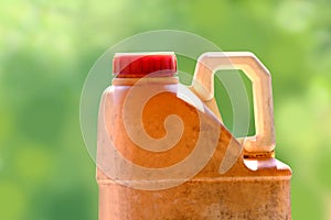 Plastic gallon yellow old of oil lubricant on blurred green background, close up old and dirty car engine oil gallon