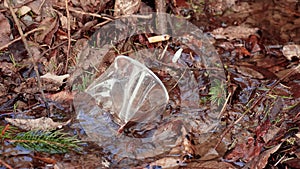 Plastic garbage and cigarette butts in clean stream water