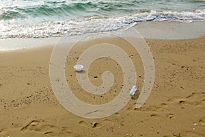 Plastic garbage and footprints on beautiful beach