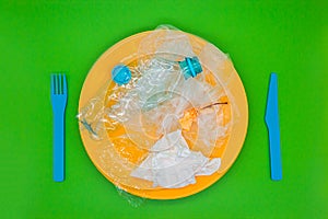 Plastic garbage on a plate, concept of junk unhealthy food