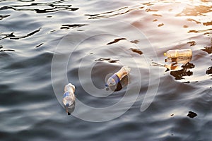 Plastic garbage in the river on sunset, environment concept