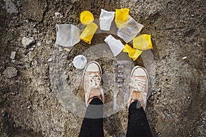 Plastic garbage underfoot.Crumpled disposable plastic glasses in yellow and white lie on the ground. The concept of an