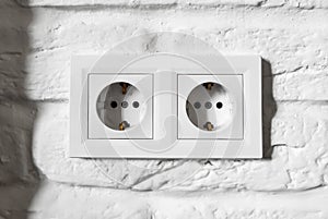 Plastic German double socket-outlets type F with grounding. Pair of empty, unplugged, european white power sockets or