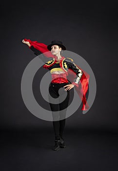 Plastic girl gracefully dancing in a stage costume stylized as a bullfighter