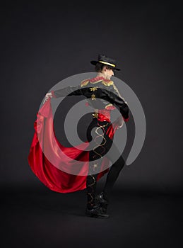Plastic girl gracefully dancing in a stage costume stylized as a bullfighter