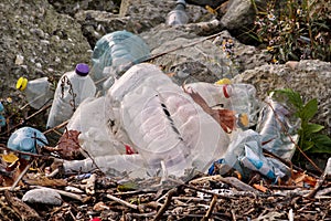 Plastic and glass bottles thrown away and left in nature, pile of garbage. Ecological, ecology, recycling industry.