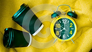 Retro clock with alarm clock top view,cappuccino in a plastic glass,wavy texture of the glass,close-up. photo