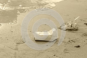 Plastic glass waste is placed at the edge of the beach.