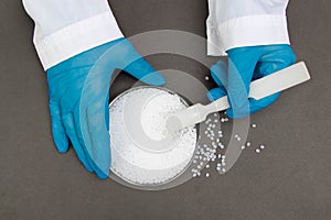 Plastic granules . Polypropylene, polyethylene pellets in hands with gloves. Quality control of plastic in the laboratory in